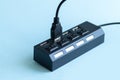 Black USB hub with usb cable plug on blue background Royalty Free Stock Photo