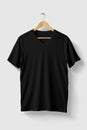 Black V Neck T Shirt mockup on wooden hanger isolated on light grey background front side view. Royalty Free Stock Photo
