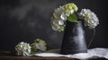 a black vase with white and green flowers in front of a black wall and a white napkin on a wooden table with a white cloth Royalty Free Stock Photo