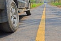 Black vehicle on asphalt road with yellow line