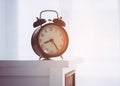 Black Vintage alarm clock on bed side table Royalty Free Stock Photo
