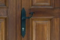 Black vintage metal door handle on brown wooden doors. Royalty Free Stock Photo