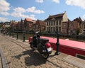 Black vintage scooter parked near the fence on embankment of the Lys River dutch: Leie. Royalty Free Stock Photo