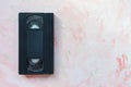 Black vintage VHS video tape on pink background