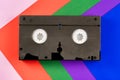 Black vintage VHS videotape on red, blue, green, purple and pink background. Plastic retro video cassette with analog Royalty Free Stock Photo