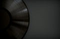 Black Vinyl Record with a Black Label on a Black Surface. Dark Music Background with Copy Space.