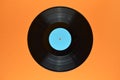 Black vinyl record on orange background