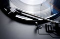 Black vinyl record spinning on a turntable - close up of a tonearm and turn table Royalty Free Stock Photo