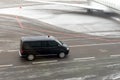 Black VIP service van running on airport taxiway with blurred private jet on background. Business class service at
