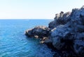 Black volcanic cliffs on the shores of the Mediterranean Sea in Italy. Catania, Sicily