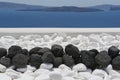 Black volcanic stones over white. Decoration detail at Santorini island Royalty Free Stock Photo