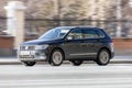 Black Volkswagen Tiguan at the city street in motion. Second generation SUV fast drive on road with blurred background