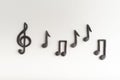 Black volumetric notes and violin key on white background top view. treble clef. Key of G