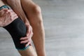 Black voluminous sports or medical knee pad with a fixator, to support the knee joint on male knee Royalty Free Stock Photo