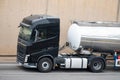 Black Volvo FH truck loading a white container trailer along Barcelona's Ronda Litoral