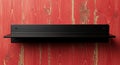 Black wall shelf on rustic red wooden background Royalty Free Stock Photo