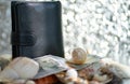 Black wallet and dollar and seashells on a silver background. blurred focus Royalty Free Stock Photo