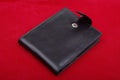 Black leather wallet on red background money purse finance shopping currency object business wealth cash single pay rich personal