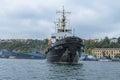 Black warship of the Russian Black Sea Fleet against the background of other ships in the port of Sevastopol.