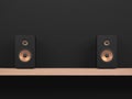 Black 2 way hi fi speakers with golden speaker driver on wooden shelf and dark background Royalty Free Stock Photo