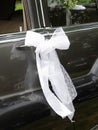 A black wedding car decorated with white loop