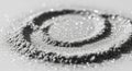 Black and white abstract close-up of concentric circles formed by scattered particles creating textured pattern with curled edges Royalty Free Stock Photo