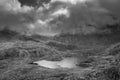 Black and white Aerial view of flying drone Epic landscape image of Llyn Bochlwyd in the mountains in Snowdonia National Park with Royalty Free Stock Photo