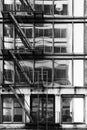 Black and white art photograph of classic vintage New York City loft building with fire escape and large glass window reflection.