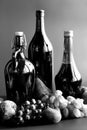 Black and white autumn still life with wine bottles and fruits. Royalty Free Stock Photo