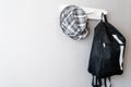 Black and white Backpack and scott hat Hanging On white Wall