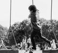 Black and white candid shot of Active kid climbing rope in the playground, High key light of Rare view of Child enjoying activity