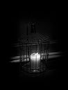 Black and White Candle Shining in a Cage in the Dark