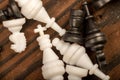 Black and white chess pieces scattered on a wooden table, close-up, selective focus Royalty Free Stock Photo