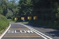 Black and white chevrons, a double white line and a skid risk warning sign tell drivers to slow down because there is danger ahead