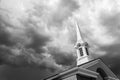 Black and White Church Steeple Tower Below Ominous Stormy Thunderstorm Clouds. Royalty Free Stock Photo