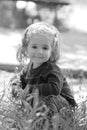 Black and white close up of extremely cute little one year old girl sitting in the grass Royalty Free Stock Photo