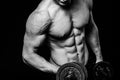 Black and white close-up of handsome power athletic mans hand stomach abs in training pumping up muscles with dumbbells Royalty Free Stock Photo