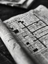 Black and white close-up of a partially completed crossword puzzle on a newspaper. Royalty Free Stock Photo