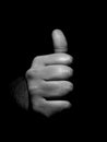 Black and white close up photo of man gesturing a thumbs up sign