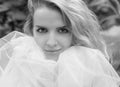 A black and white close-up portrait of a girl with a smile and a white tulle skirt, looking at the camera. Royalty Free Stock Photo