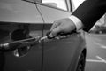 Black and white closeup of man inserting car key in the hole Royalty Free Stock Photo