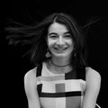 Black and white closeup portrait of a beautiful happy smiling young girl, wind blows her hair Royalty Free Stock Photo