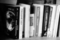 Black and white closeup shot of row of novels by different authors in Polish language on shelf.