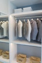 Cloths hanging in wooden wardrobe at home Royalty Free Stock Photo