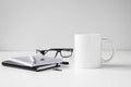 Black and white coffee mug mock up with notebooks, pen and eyeglasses Royalty Free Stock Photo