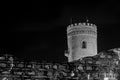 Black and white composition of medieval ruin of a watch tower at night with stone wall in the foreground Royalty Free Stock Photo