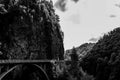 Black and white composition of mountain road passing through forest covered rocky mountain and large forest on Transfagarasan Royalty Free Stock Photo
