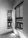 Black and white of Corner of two Interleaved wooden ornate windows - Mashrabiya - in stone wall Royalty Free Stock Photo