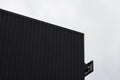 Black and white Corrugated metal sheet texture surface on a building wall with a cloudy sky. Galvanize steel background. Royalty Free Stock Photo