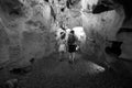 Black and white. Couple of tourists exploring the cave. The interior of the cave. Touristic hiking route. Concept of excursions